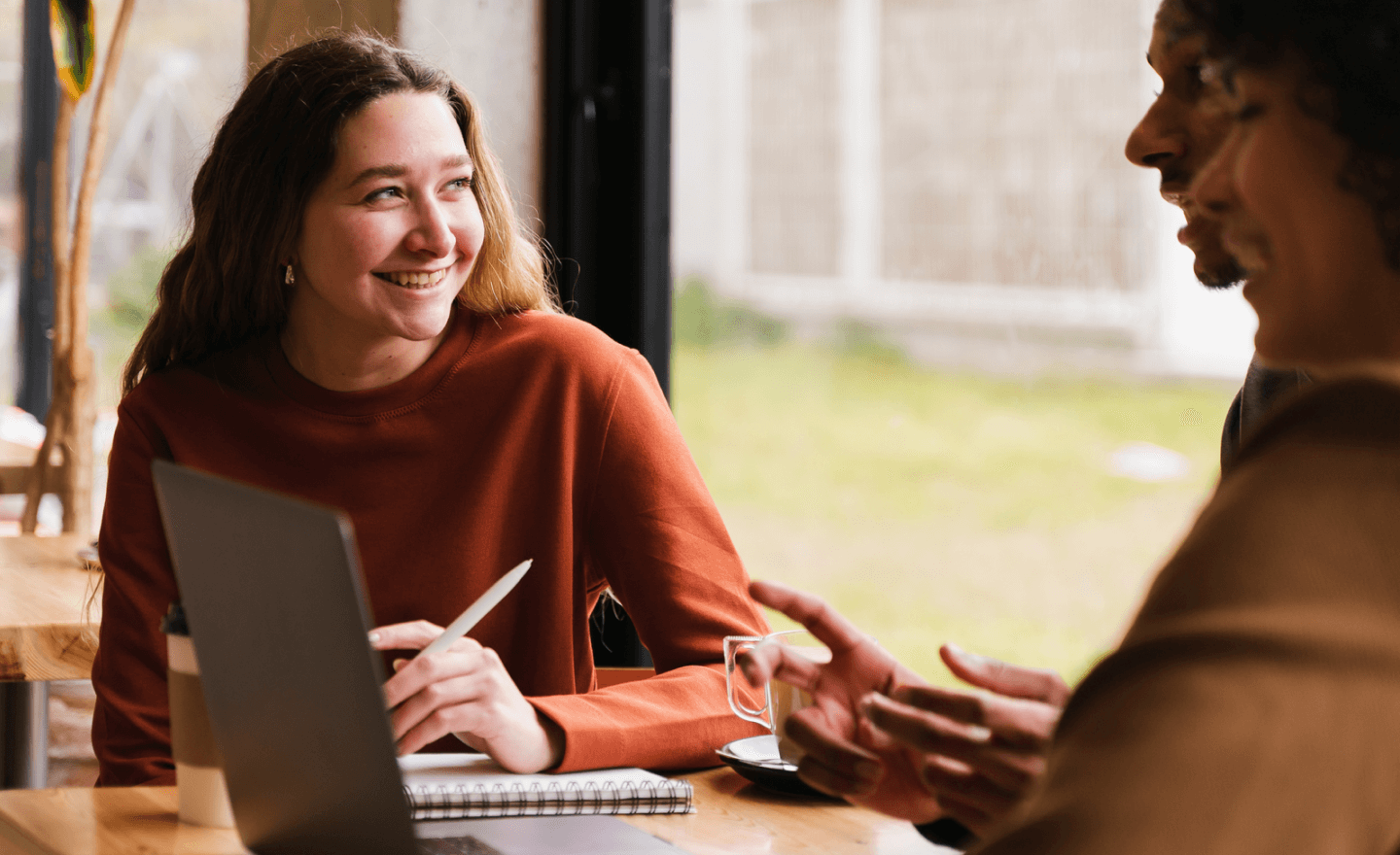 Woman smiling next to two coworkers