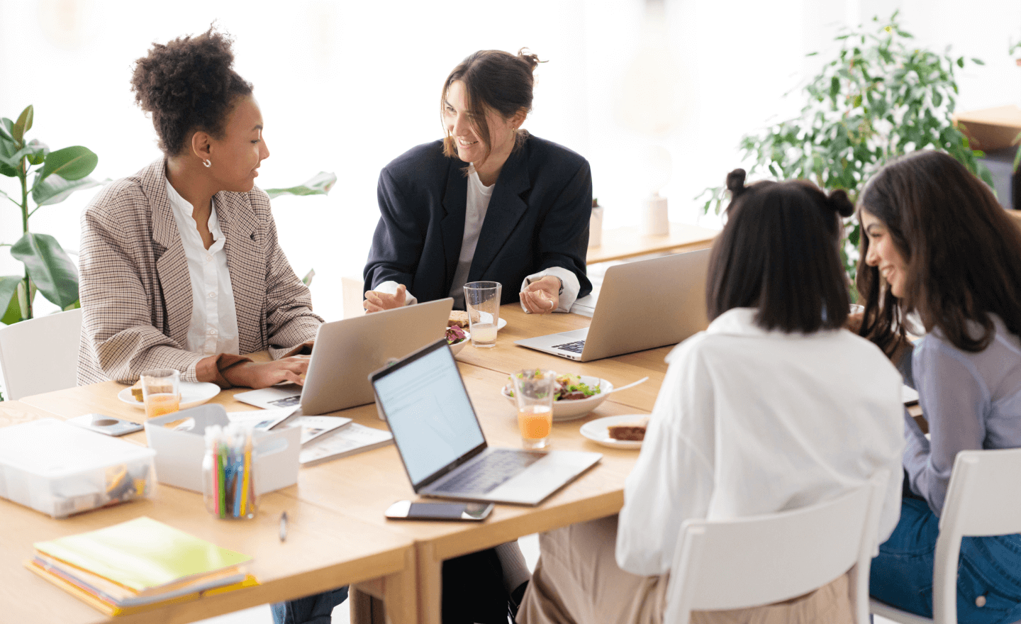 Image of a happy group of women working together with laptops at a table