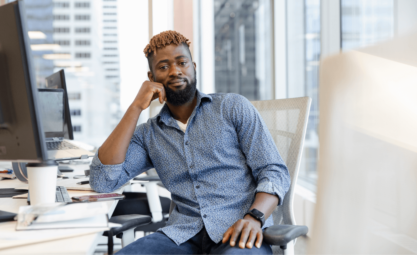 Image of a man at a desk looking confidently at the camera